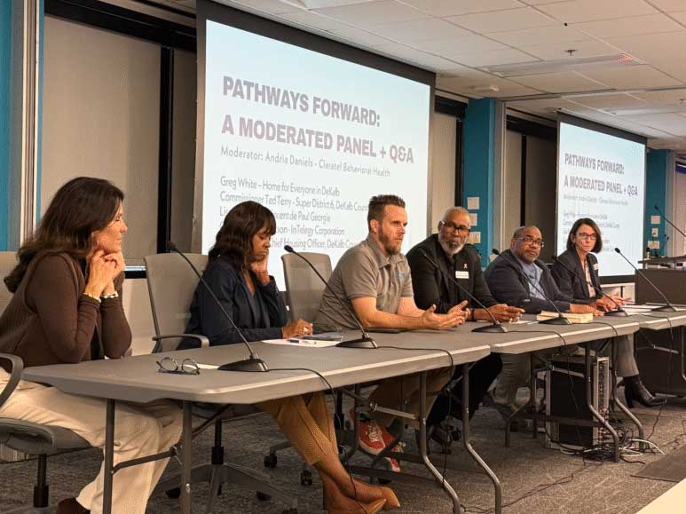 Panel discussion with six speakers seated at a table, microphones in front, under a "Pathways Forward" presentation slide.