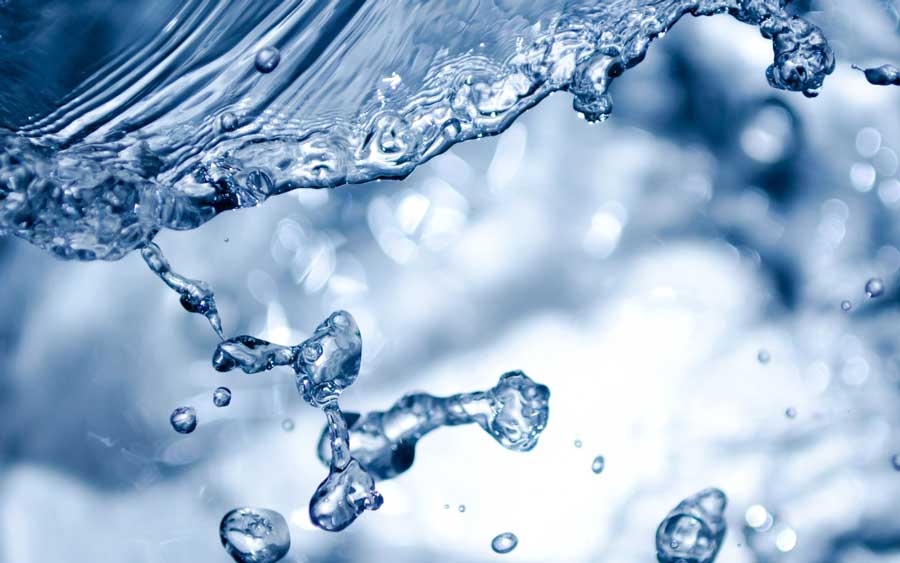 Close-up of clear water splashing with droplets and ripples on a blurred background.